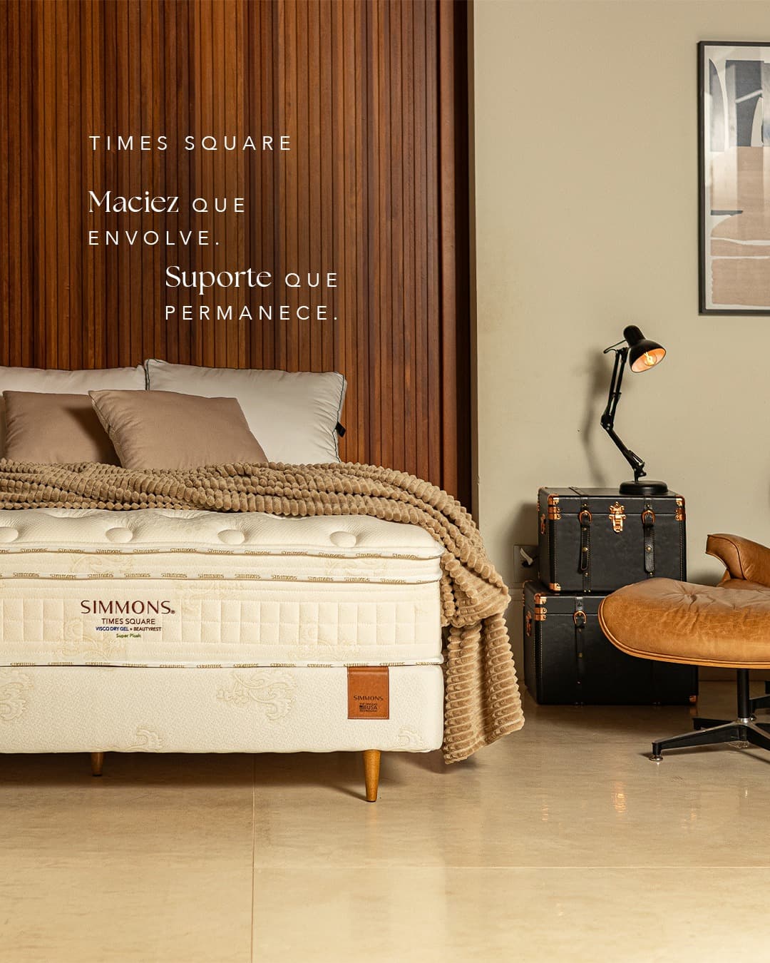 Conjunto box Simmons Times Square diante de uma parede ripada de madeira, com a legenda “Maciez que envolve. Suporte que permanece.”